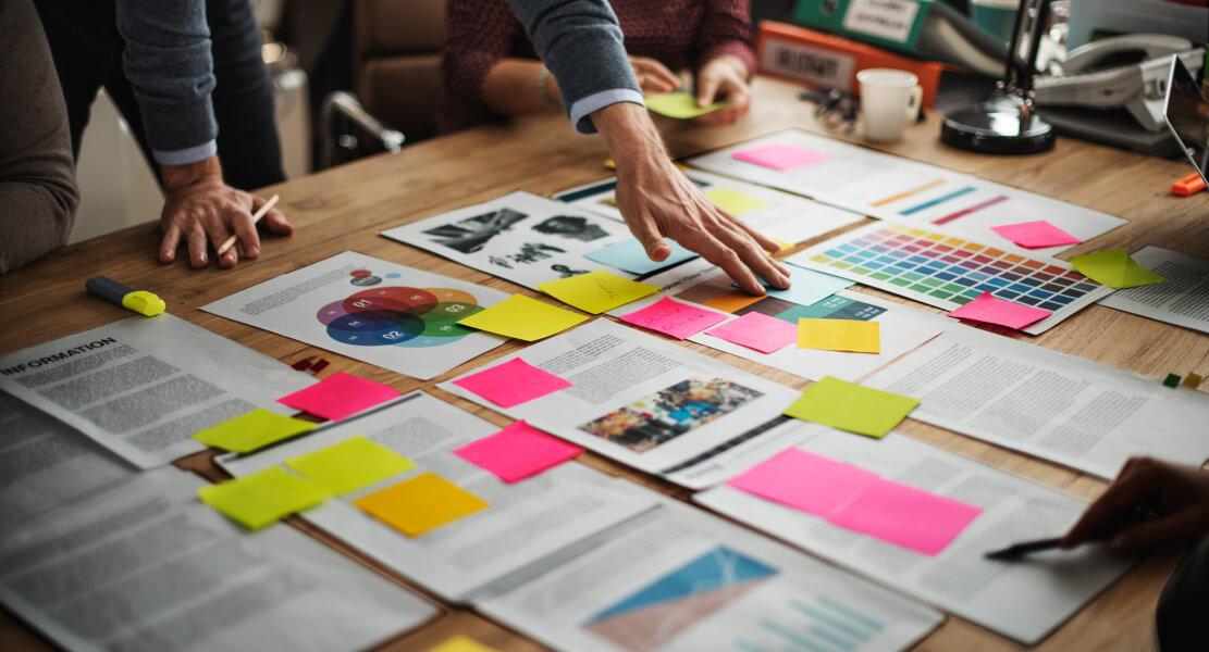 The following image shows a man creating a marketing strategy with his colleagues.