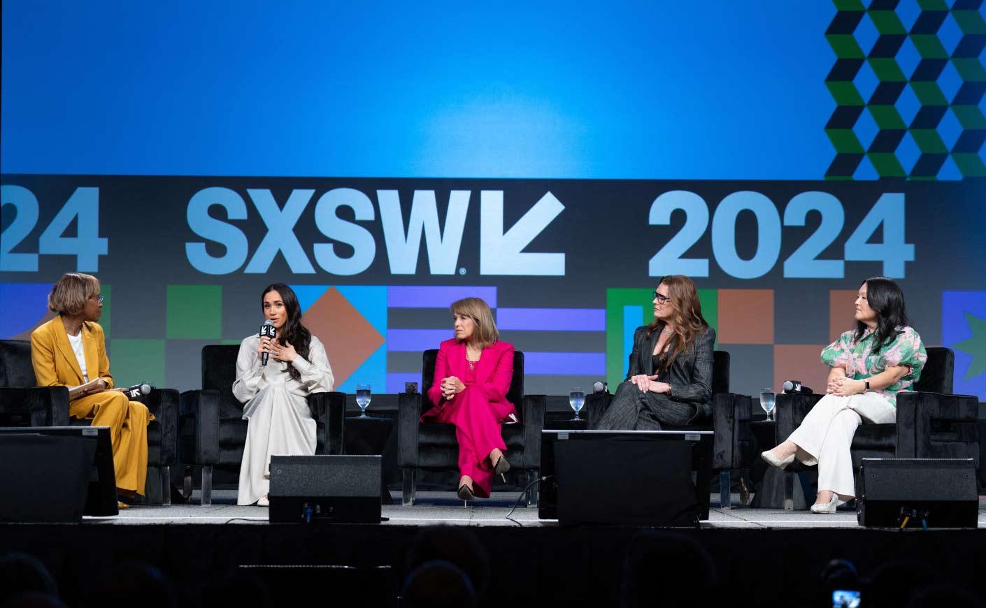 Panel discussion at sxsw 2024 event with five individuals on stage actively engaged in conversation