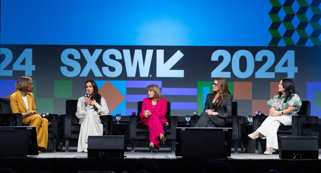 Panel discussion at sxsw 2024 event with five individuals on stage actively engaged in conversation